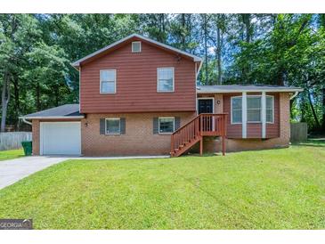 Charming two-story home with brick and wood exterior and lush green lawn at 5207 Shawn Ln, Stone Mountain, GA 30088