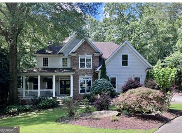 Charming two-story home with stone accents, a welcoming front porch, and beautiful landscaping at 1788 River Bluff Vw, Duluth, GA 30097