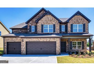 Two-story brick home featuring a three-car garage, black shutters and a manicured lawn at 1172 Faulkner Way, Jonesboro, GA 30238