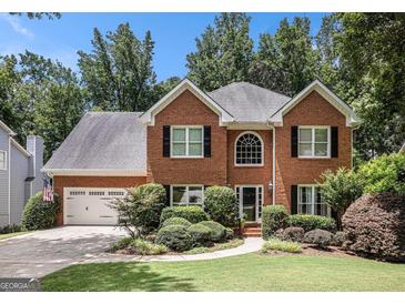 Charming brick home with lush landscaping and a well-manicured lawn creating great curb appeal at 1884 Whitehawk Ct, Lawrenceville, GA 30043