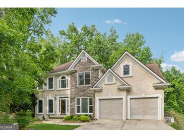 Charming two-story home with stone accents, manicured lawn, and an attached two-car garage at 3355 Golfe Links Dr, Snellville, GA 30039