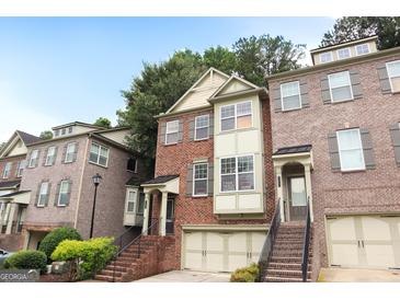 Charming brick townhome featuring a two-car garage and well-maintained landscaping at 2084 Cobblestone Ne Cir, Brookhaven, GA 30319