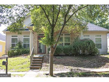 Inviting single-story home with brick facade, lush landscaping, and charming front porch at 6127 Landers Loop, Fairburn, GA 30213
