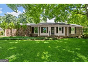Charming brick home with a well-manicured lawn and inviting front porch at 2826 Summit Ridge Dr, Marietta, GA 30066
