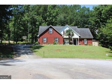Charming brick home with well-manicured lawn and mature trees offering a serene suburban setting at 25 Castlehill Ct, Covington, GA 30016
