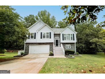 Charming two-story home featuring a stone facade, white siding, and a well-manicured lawn at 7030 Wessex Way, Cumming, GA 30028