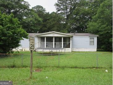 Charming single-story home with a covered front porch, well-maintained lawn, and mature trees at 322 Loblolly Ridge, Locust Grove, GA 30248