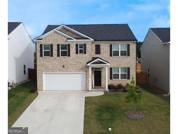 Charming two-story home featuring a brick facade, well-manicured lawn, and a two-car garage, perfect for families at 2159 Redfern, Dacula, GA 30019