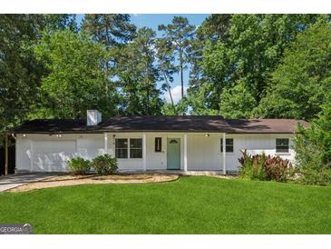 Charming single-story home featuring a well-manicured lawn and a quaint front porch at 3123 Deshong Dr, Stone Mountain, GA 30087