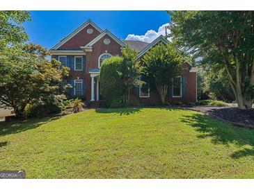 Traditional brick home with manicured lawn and mature trees and blue shutters at 901 Chadwick Park Dr, Lawrenceville, GA 30045