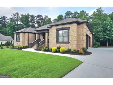 Charming brick home featuring a well-manicured lawn and professional landscaping at 4564 Investors Ln, Ellenwood, GA 30294