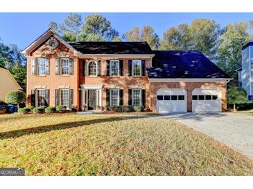 Two-story brick home with a two-car garage, black shutters, and a well-manicured lawn at 3034 Brookgreen Trl, Lawrenceville, GA 30043