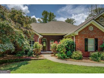 Charming brick home featuring well-manicured landscaping and an inviting front entrance at 1041 Flat Rock Rd, Covington, GA 30014