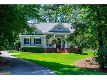 Charming single-story home with manicured lawn, mature trees, and a welcoming front porch at 7003 Tara Dr, Villa Rica, GA 30180