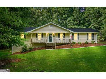 Charming single-Gathering home featuring a covered front porch and a well-maintained lawn with mature trees at 185 Downybrook Ln, Fayetteville, GA 30215