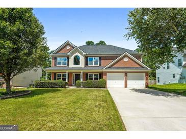 Beautiful two-story brick home with a well-manicured lawn and a two-car garage at 1209 Polk Xing, Mcdonough, GA 30252
