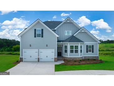 Charming two-story home featuring a two-car garage, landscaped front yard, and a mix of siding textures at 13709 Whitman Ln, Covington, GA 30014