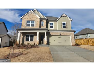 Charming two-story home featuring a two-car garage, stone accents and a well-maintained lawn at 504 Clayborne Way # 248A, Loganville, GA 30052