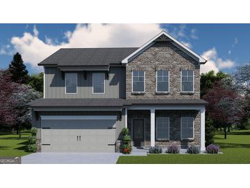 Charming two-story home with brick and gray siding, featuring a two-car garage and manicured lawn at 504 Clayborne Way # 248A, Loganville, GA 30052