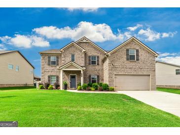 Beautiful two-story brick home with a well-manicured lawn on a sunny day at 209 Osier Dr, Mcdonough, GA 30252