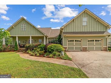 Inviting home with an attached two-car garage and a beautifully landscaped front yard and walkway at 9360 Ward Rd, Winston, GA 30187