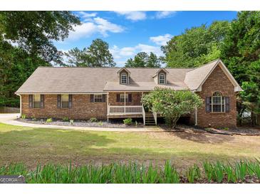 Charming brick home with dormer windows, mature trees, and a well-maintained front lawn at 116 Alexander Dr, Mcdonough, GA 30252
