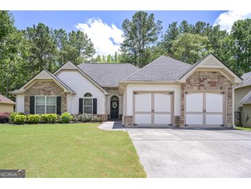 Charming home featuring a well-manicured lawn, stone accents, and a two-car garage at 170 Saddleridge Dr, Bremen, GA 30110