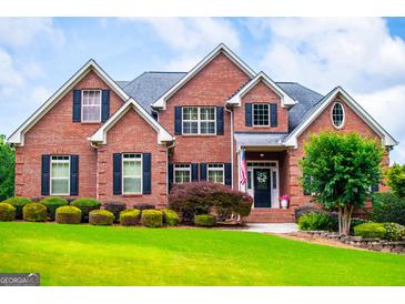 Beautiful brick home featuring a well-manicured lawn and lush landscaping at 713 Birkdale Blvd, Carrollton, GA 30116
