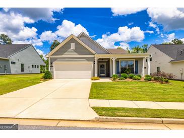 Charming single-story home featuring a well-maintained lawn and an attached two-car garage at 326 Elkins Place, Peachtree City, GA 30269