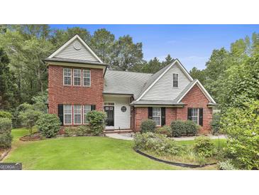 Charming two-story brick home with a manicured lawn and mature landscaping at 128 Rubicon Rd, Peachtree City, GA 30269