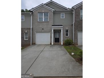 Charming townhome featuring a one-car garage and inviting front entrance with classic architectural details at 846 Hughes Trce, Stone Mountain, GA 30083