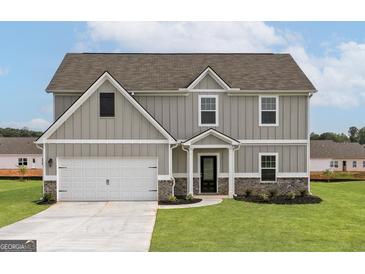 Charming two-story home with gray siding, white trim, a two-car garage, and a well-maintained lawn at 275 Oliver Dr, Locust Grove, GA 30248