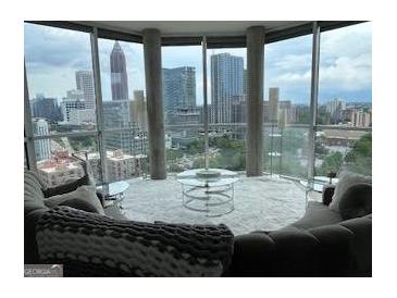 Bright living room with floor-to-ceiling windows showcasing a stunning city skyline view at 285 Centennial Olympic Park Drive Northwest Nw Dr # 1905, Atlanta, GA 30339