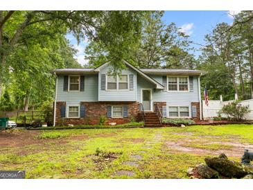Charming two-story home with light blue siding, brick accents, and a lush green lawn at 201 Greensprings Dr, Palmetto, GA 30268