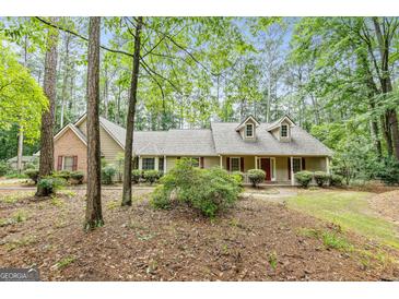 Charming home boasts a welcoming front porch, dormer windows, and a blend of brick and siding at 215 Longwood Dr, Jonesboro, GA 30236