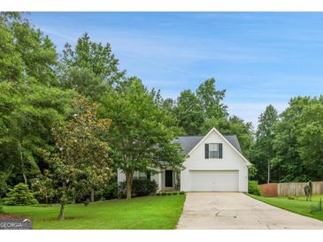 Charming single-Gathering home with a well-maintained lawn, mature trees, and attached two-car garage at 52 Cherub Ln, Sharpsburg, GA 30277
