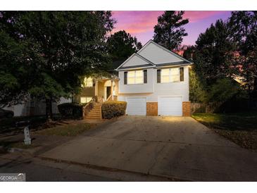 Two-story home with vinyl siding, a driveway, a two-car garage, and a charming entrance with steps at 375 Sapphire Bnd, Riverdale, GA 30296