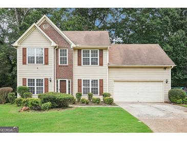 Two-story home featuring a brick facade, neutral siding, manicured lawn, and two car garage at 2580 Star Ln, Decatur, GA 30034