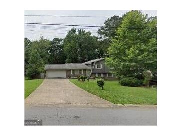 Charming single-Gathering home with attached garage and well-maintained front yard at 7313 Grayson Dr, Riverdale, GA 30296