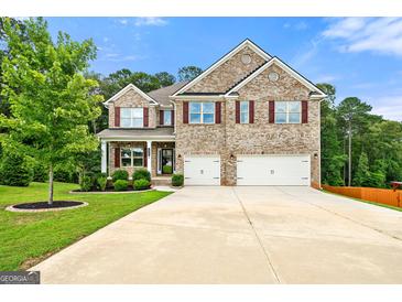 Charming two-story brick home with a well-manicured lawn and a spacious three-car garage at 3865 Rifflepool Ct, Douglasville, GA 30135