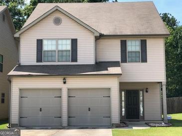 Charming two-story home featuring a two-car garage and a welcoming front entrance at 7609 Garnet Dr, Jonesboro, GA 30236