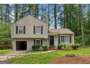 Charming two-story home features a landscaped front yard and attached one car garage at 447 Sherwood Cir, Stone Mountain, GA 30087