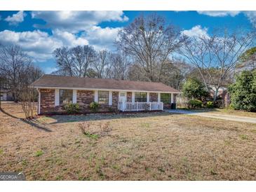 Charming brick home featuring a well-manicured front yard and inviting entrance at 11 Grove Ln, Hampton, GA 30228