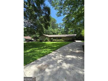 Lovely one-story home boasts a lush green lawn and long concrete driveway at 2527 Amalfi Dr, Conyers, GA 30012