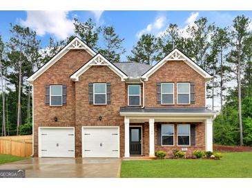 Beautiful two-story brick home featuring a welcoming entrance, manicured lawn, and two-car garage, perfect for Gathering living at 1184 Bluecoat Cir # 84, Hampton, GA 30228