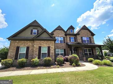 Charming two-story brick home with well-manicured landscaping and inviting front porch at 206 Birchin Dr, Woodstock, GA 30188