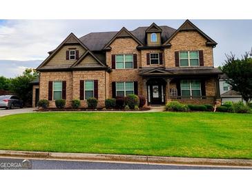 Charming two-story brick home with a manicured lawn and dark shutters at 206 Birchin Dr, Woodstock, GA 30188