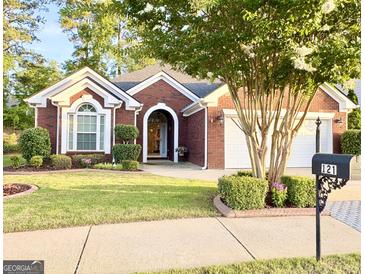 Charming brick home featuring a manicured front yard and a welcoming arched entryway at 121 Pinnacle Ln, Mcdonough, GA 30253
