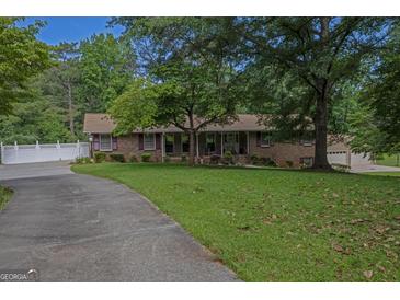 Charming brick ranch-style home with a well-manicured front lawn and mature trees at 183 Inman Rd, Fayetteville, GA 30215