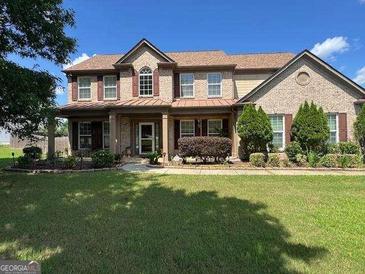 Charming two-story home with a well-maintained lawn and inviting front porch, with beautiful brick facade at 7880 Cavendish Pl, Suwanee, GA 30024